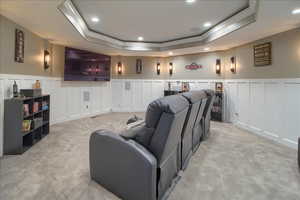 Cinema featuring a decorative wall, wainscoting, ornamental molding, a tray ceiling, and recessed lighting