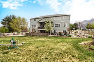 Back of property with a patio, a balcony, and a mountain view
