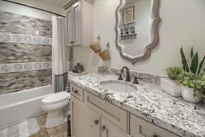 Full bath with vanity, light wood-style flooring, and shower / tub combo with curtain