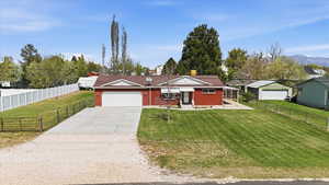 View of front of house with driveway, brick siding, a garage, a chimney, and a mountain view
