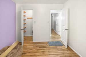 Hall with light wood-style flooring and baseboards