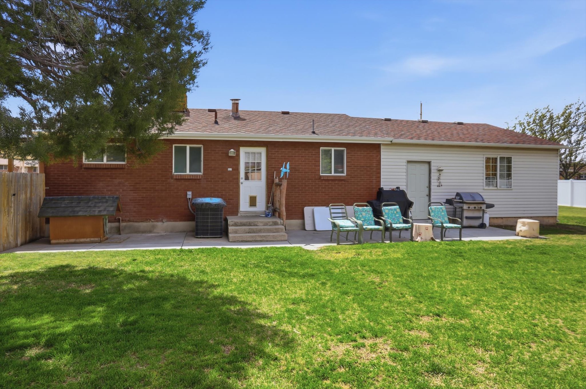 Rear view of property with a patio, entry steps, brick siding, and roof with shingles