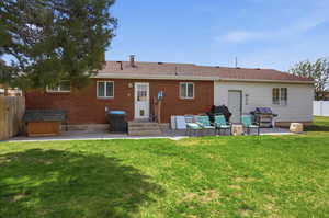 Rear view of property with a patio, entry steps, brick siding, and roof with shingles