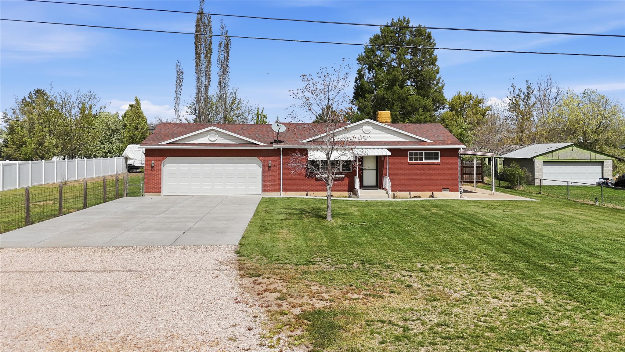 Ranch-style home with concrete driveway, brick siding, a chimney, and a garage