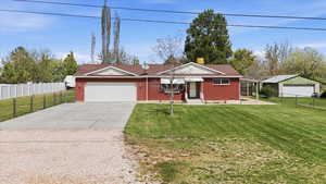 Ranch-style home with concrete driveway, brick siding, a chimney, and a garage