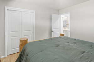 Bedroom with light wood-style floors and a closet