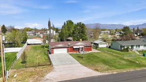 Ranch-style house with a residential view, concrete driveway, a fenced front yard, and an attached garage