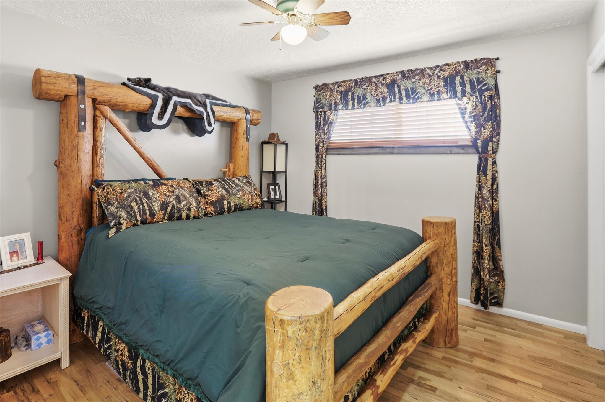Bedroom with wood finished floors, a ceiling fan, and a textured ceiling