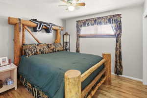 Bedroom with wood finished floors, a ceiling fan, and a textured ceiling