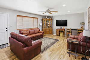 Living room with light wood-style floors, a ceiling fan, recessed lighting, and a textured ceiling