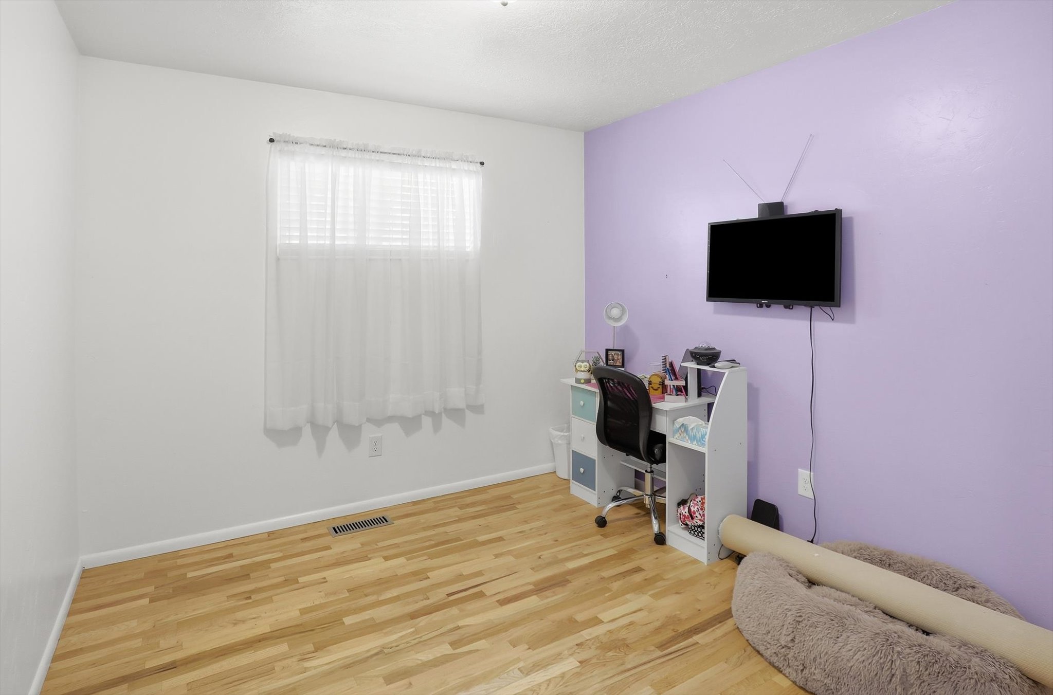 Office with light wood finished floors and a textured ceiling