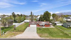 View of front of home with a residential view, driveway, a fenced front yard, an attached garage, and a porch