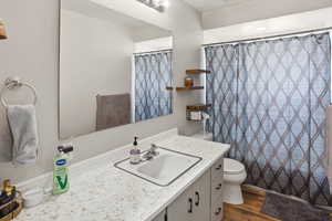 Bathroom featuring vanity, a shower with shower curtain, and dark wood-style floors