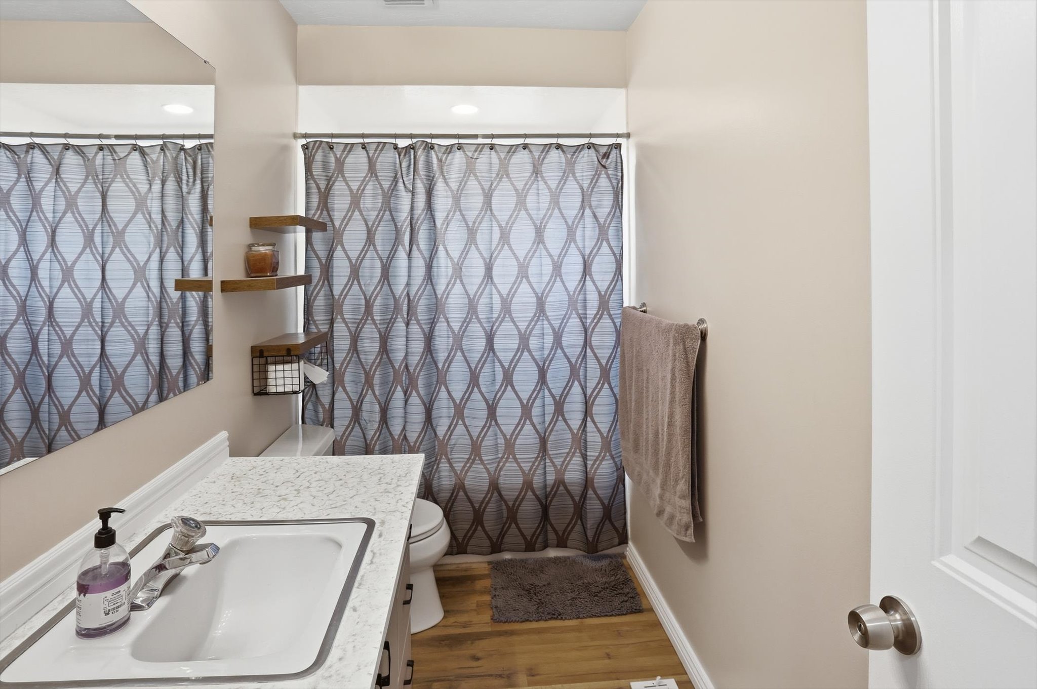 Bathroom featuring vanity, a shower with shower curtain, and light wood-style flooring