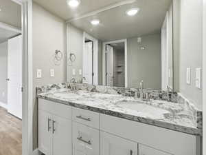 Full bathroom with double vanity, a textured ceiling, recessed lighting, and light wood finished floors