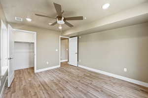 Bedroom featuring light wood-style floors, a textured ceiling, ceiling fan, recessed lighting, and a spacious closet