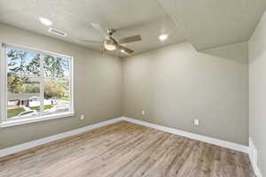 Unfurnished room featuring light wood-style floors, ceiling fan, a textured ceiling, and recessed lighting