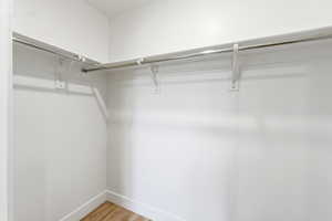 Walk in closet with light wood-style floors