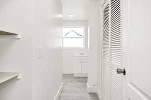 Corridor with baseboards and light wood-style flooring