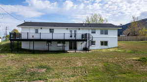 Back of property featuring a patio area, a deck, and brick siding