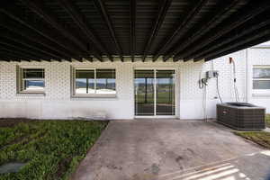 Entrance to property featuring a patio area and brick siding