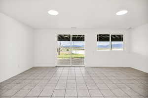 Empty room with a mountain view and light tile patterned floors