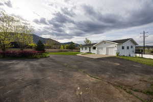 View of side of home with driveway, board and batten siding, a mountain view, and an attached garage