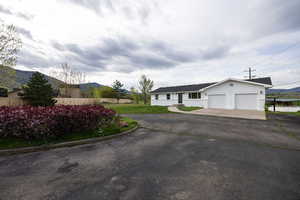 Ranch-style house featuring driveway, a mountain view, and a garage