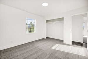 Unfurnished bedroom with light carpet and a closet