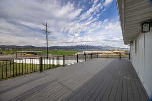 Wooden deck featuring a yard and a mountain view