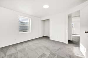 Empty room featuring light colored carpet and baseboards