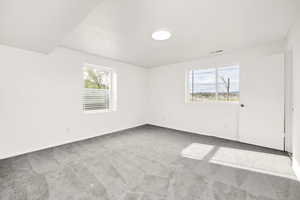 Unfurnished room with light colored carpet and healthy amount of natural light
