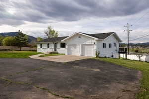 View of front of home with board and batten siding, a shingled roof, driveway, a garage, and a mountain view