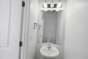 Main Floor Half bath featuring a sink and toilet