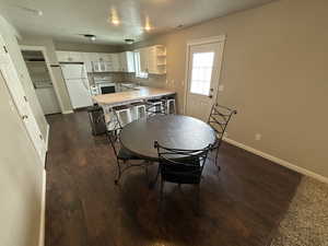 Dining space with washer / clothes dryer and dark wood-type flooring