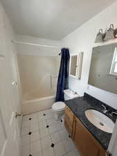Full bathroom with vanity, shower / bath combination with curtain, and light tile patterned flooring