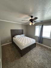 Bedroom featuring dark colored carpet, a ceiling fan, and a textured ceiling