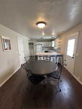 Dining area featuring dark wood finished floors, separate washer and dryer, and a textured ceiling