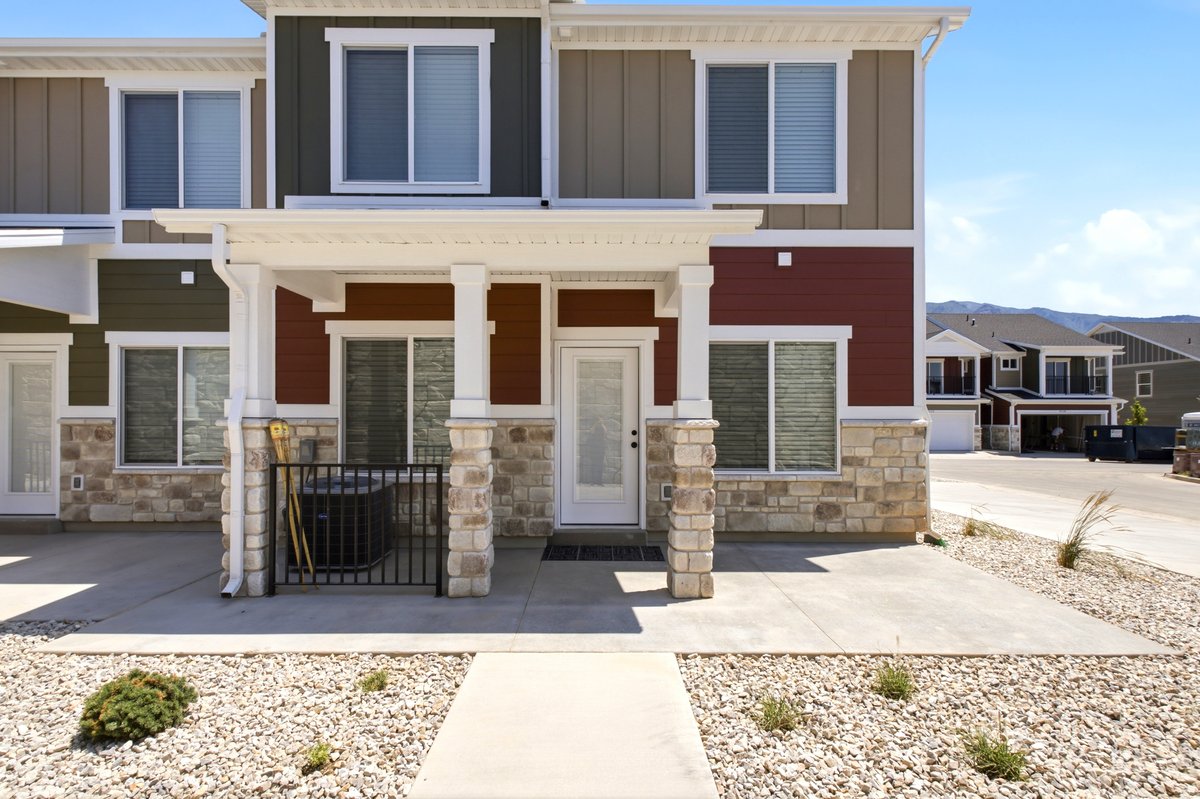 Modern townhome exterior featuring stone veneer accents and multi-toned siding