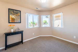 Carpeted spare room with baseboards