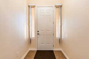 Doorway to outside with baseboards and a textured wall