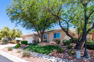 View of front of house featuring a garage, stucco siding, a tiled roof, and a front yard