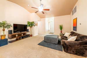 Living area featuring carpet, ceiling fan, and lofted ceiling