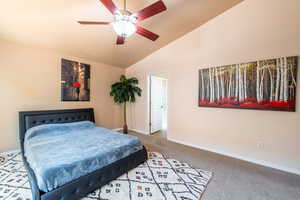 Carpeted bedroom featuring lofted ceiling and ceiling fan