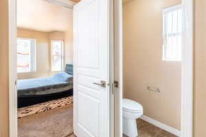 Ensuite bathroom with toilet and light tile patterned floors