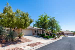 View of front of house with a tiled roof, a garage, stucco siding, and concrete driveway