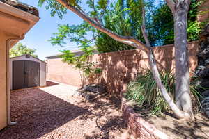 Fenced yard featuring a storage shed