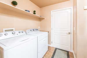 Laundry room featuring washer and clothes dryer and light tile patterned floors
