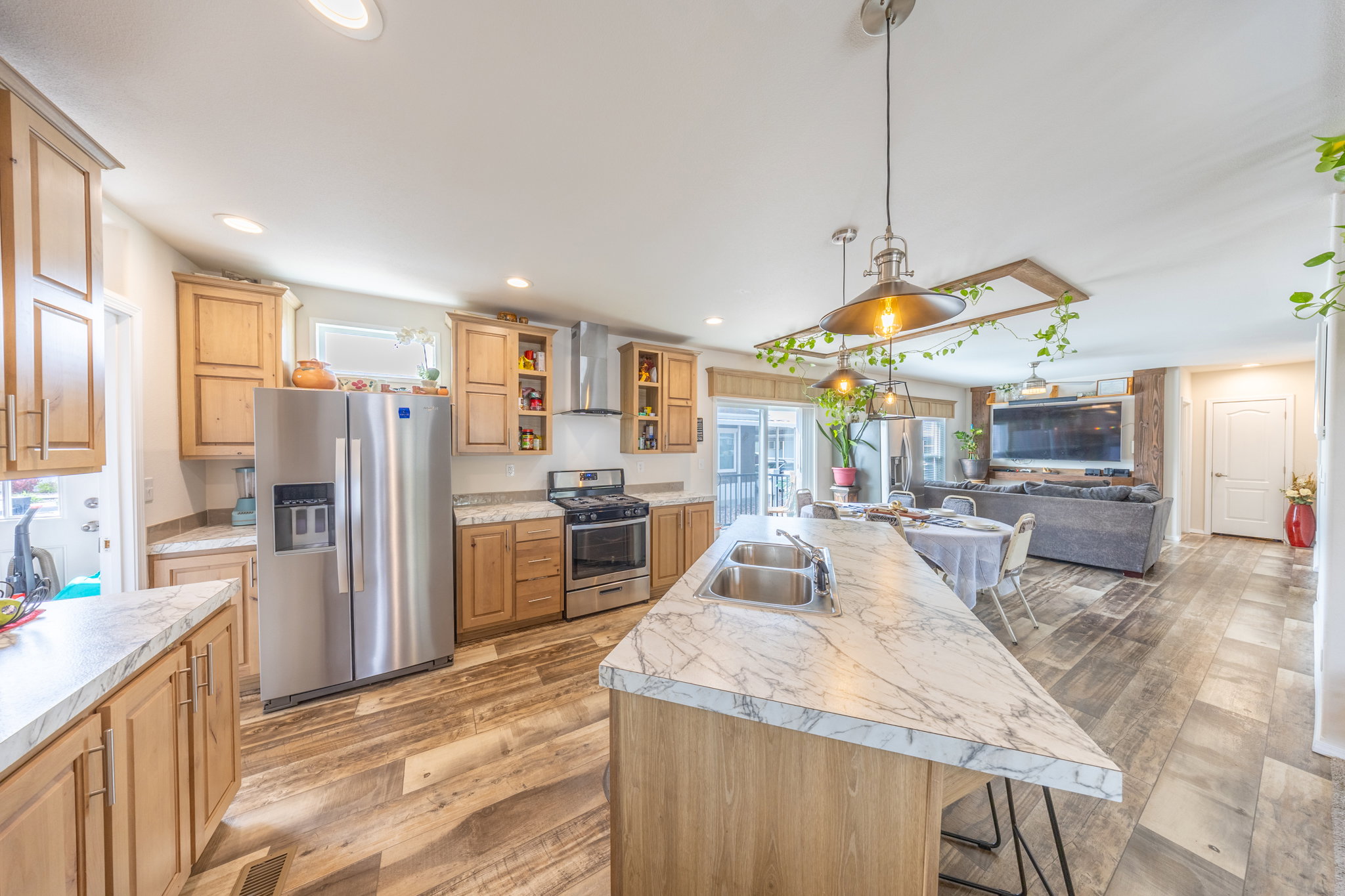 Kitchen featuring stainless steel appliances, light wood-style floors, a breakfast bar area, and open floor plan