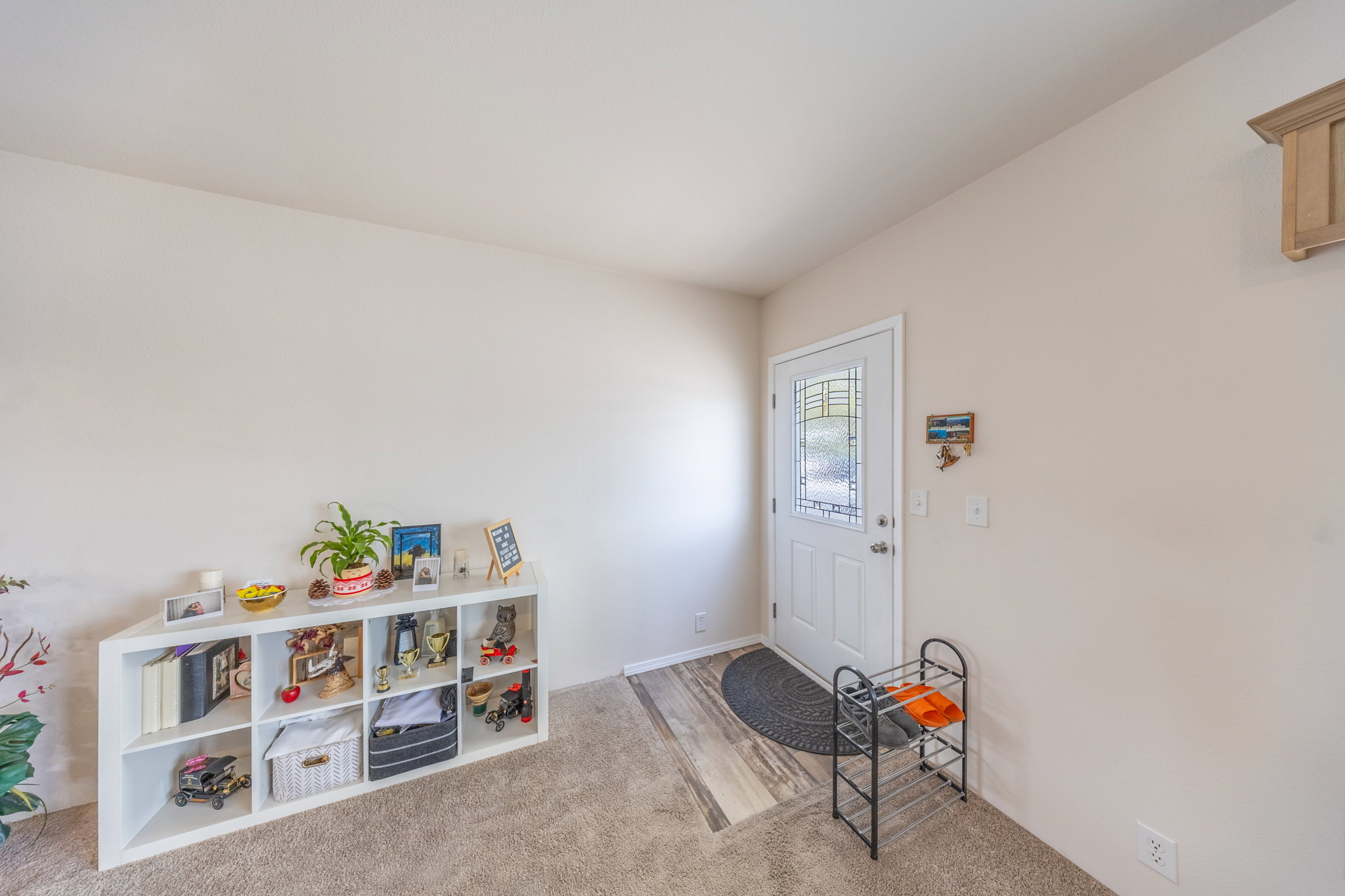 Entrance foyer with light colored carpet